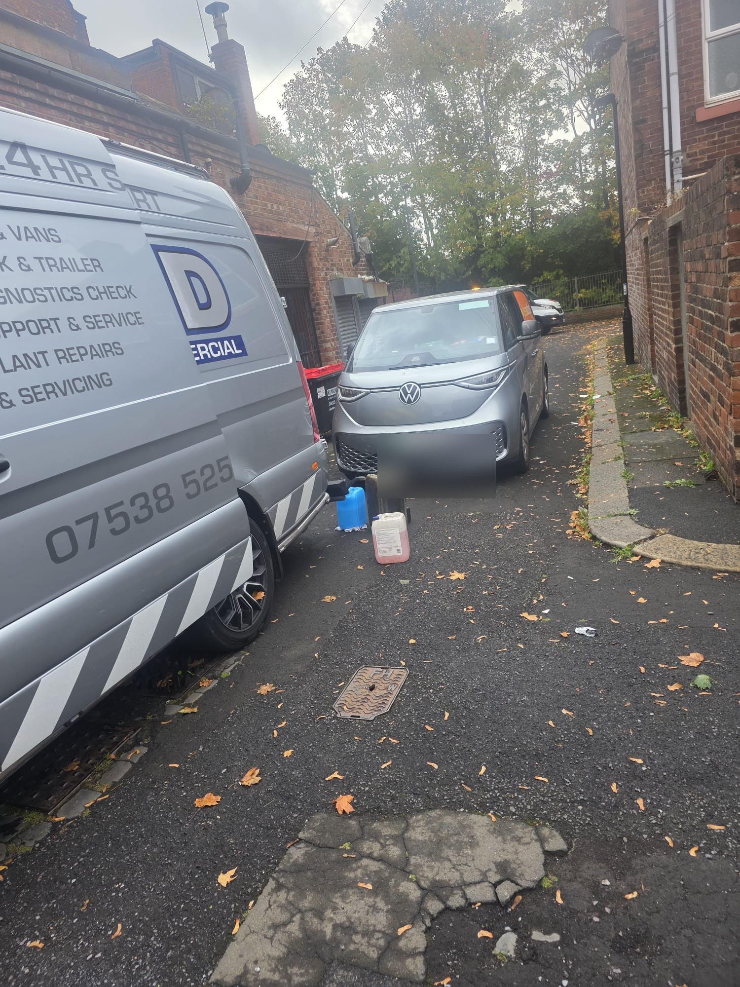 An ALD van parked next to a modern electric van down a narrow alley