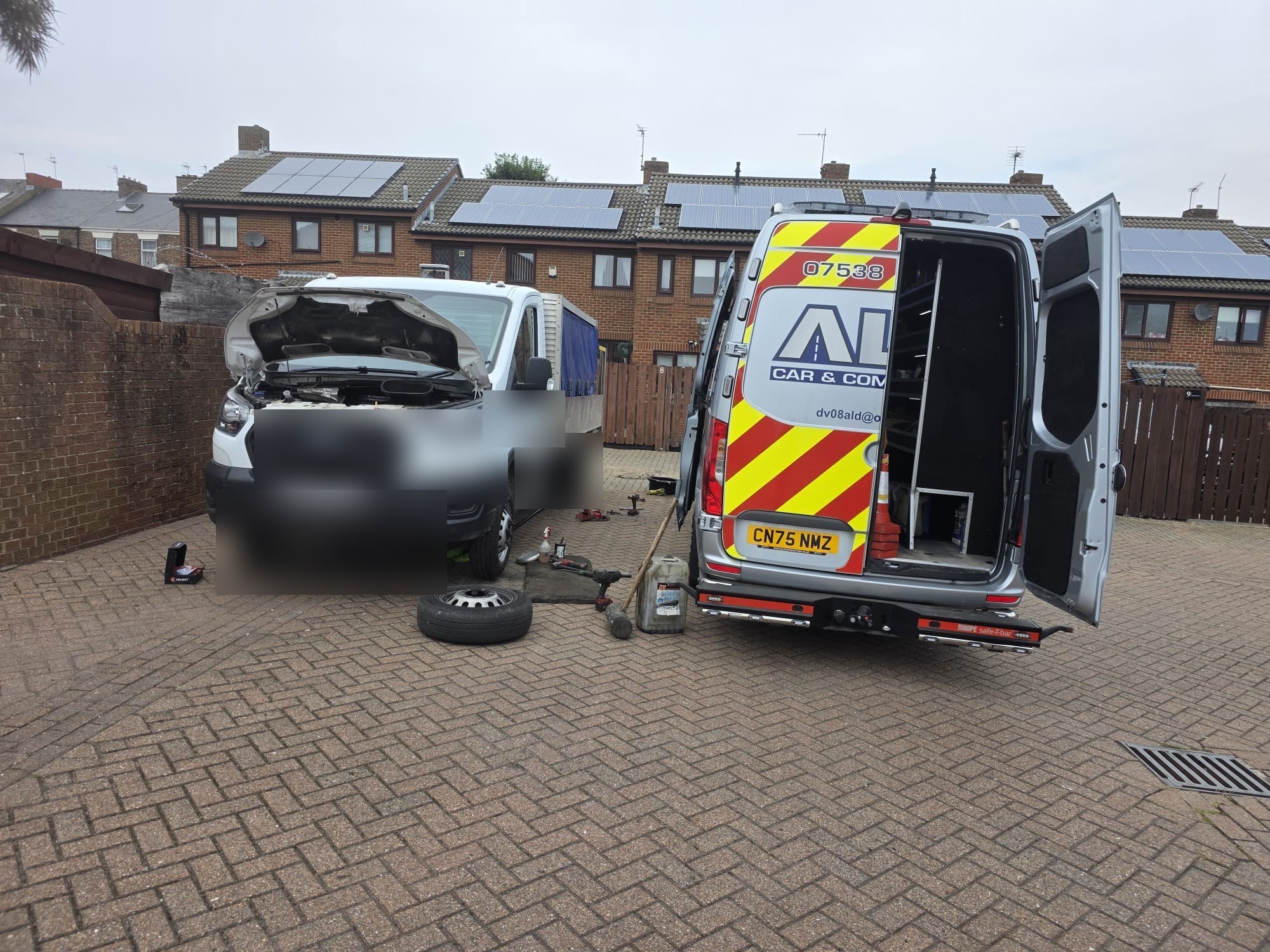 An ALD van with its doors open behind a construction tipper truck